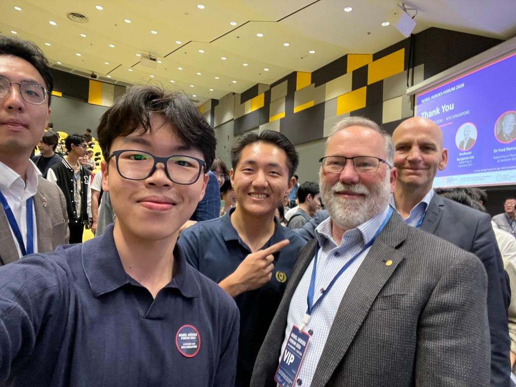 Justin Yu taking a selfie with Dr Fred Ramsdell and Professor Benjamin List at the Nobel Heroes Forum 2026.